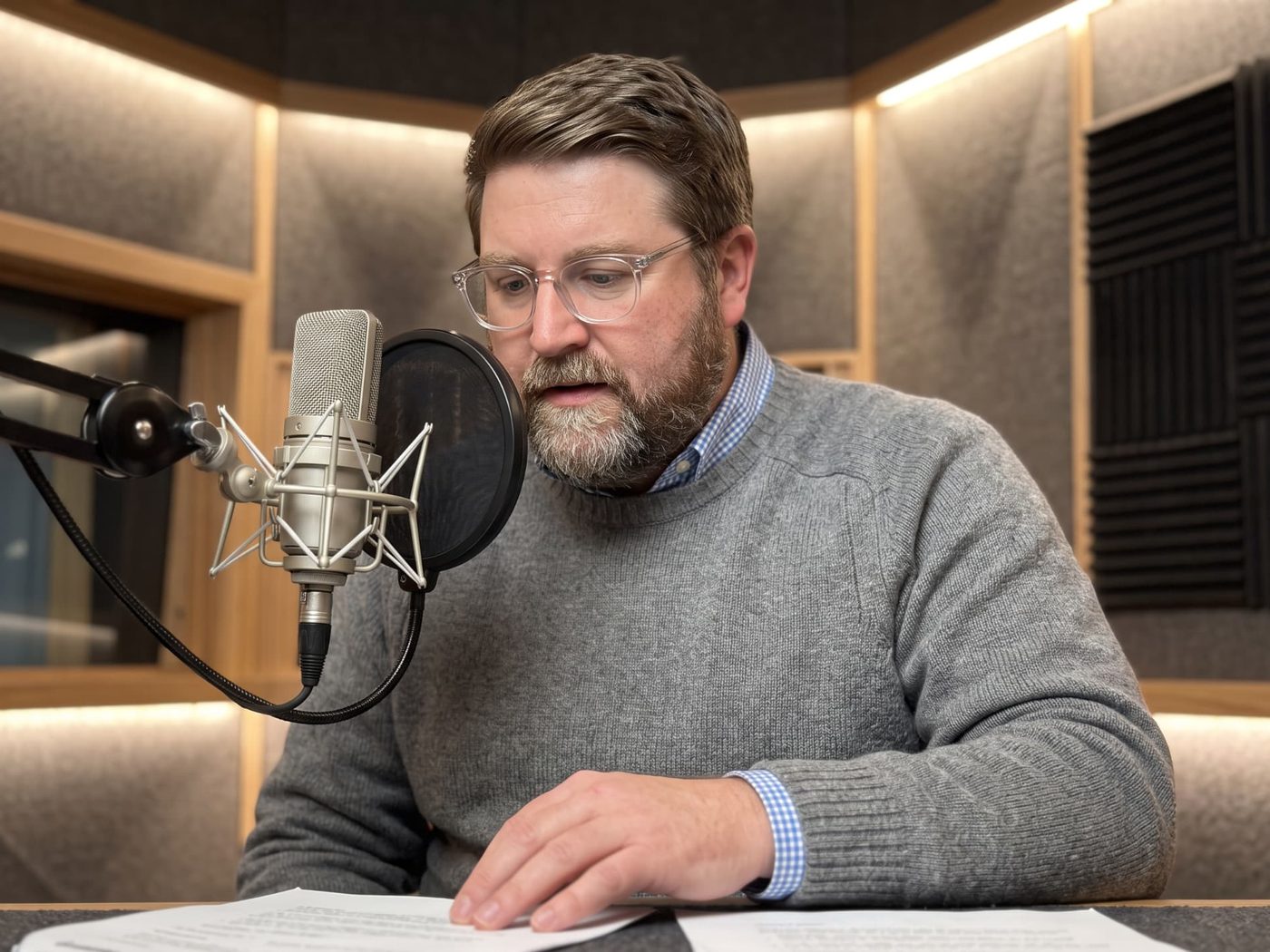 Tanner O. Campbell recording a podcast episode at a studio microphone